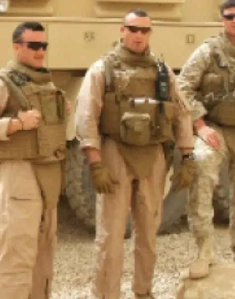 Tom Doucette (far right) with his Iraq team members in front of the truck that hit an IED bomb.