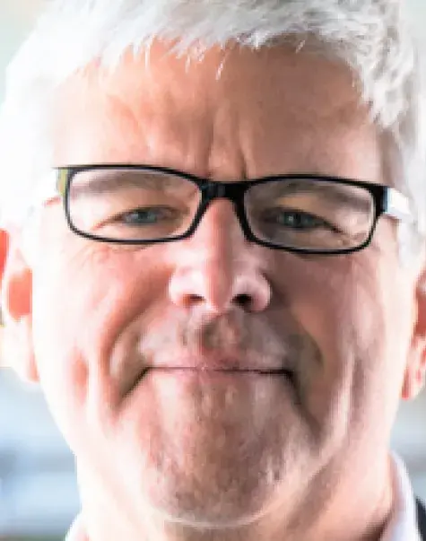 Peter brown in the center with a blurry background.