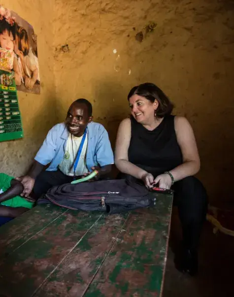 Sheila Davis sits at a table in a concrete room with a Black man, woman and child
