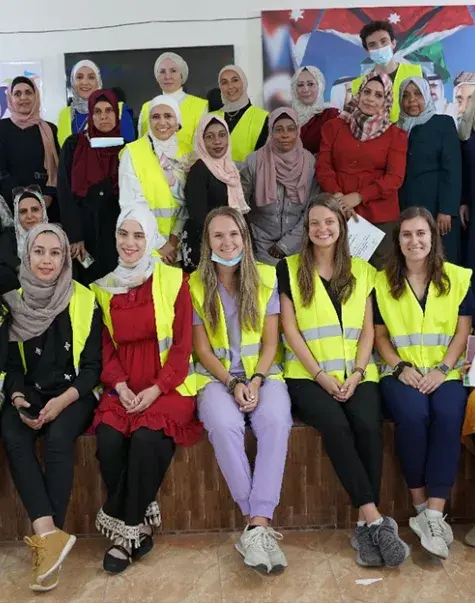 group of women some wearing hijabs some wearing yellow vests