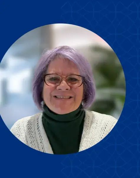 paula has purple hair and dark red rimmed glasses