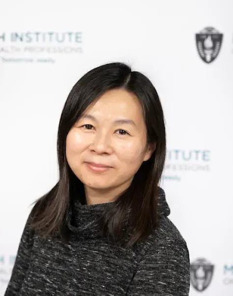 kim has a mottled black cowl neck shirt on and is Asian presenting