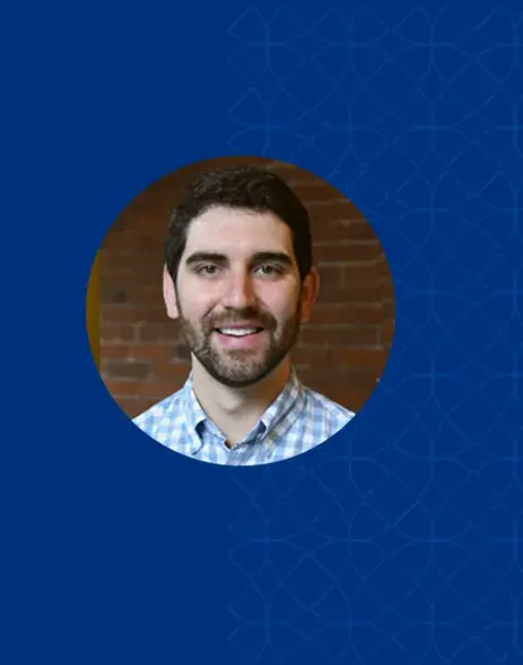 michael has a beard and moustache and wears a blue plaid shirt