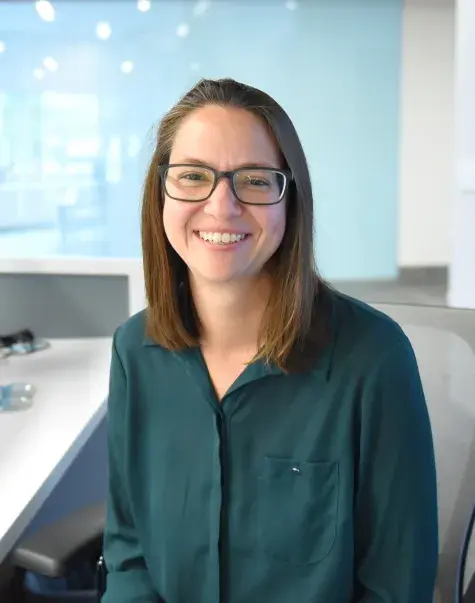 Woman sits at desk and smiles