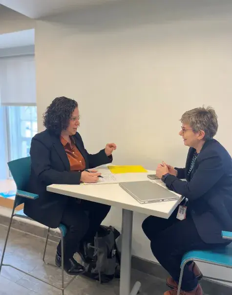 two women sit and discuss