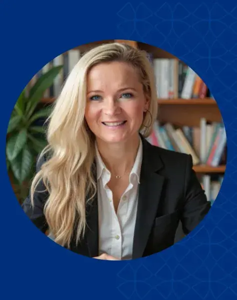 Women with long blonder hair smiling and wearing a black jacket