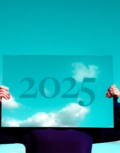 a person holding a mirror in front of their face reflecting the sky