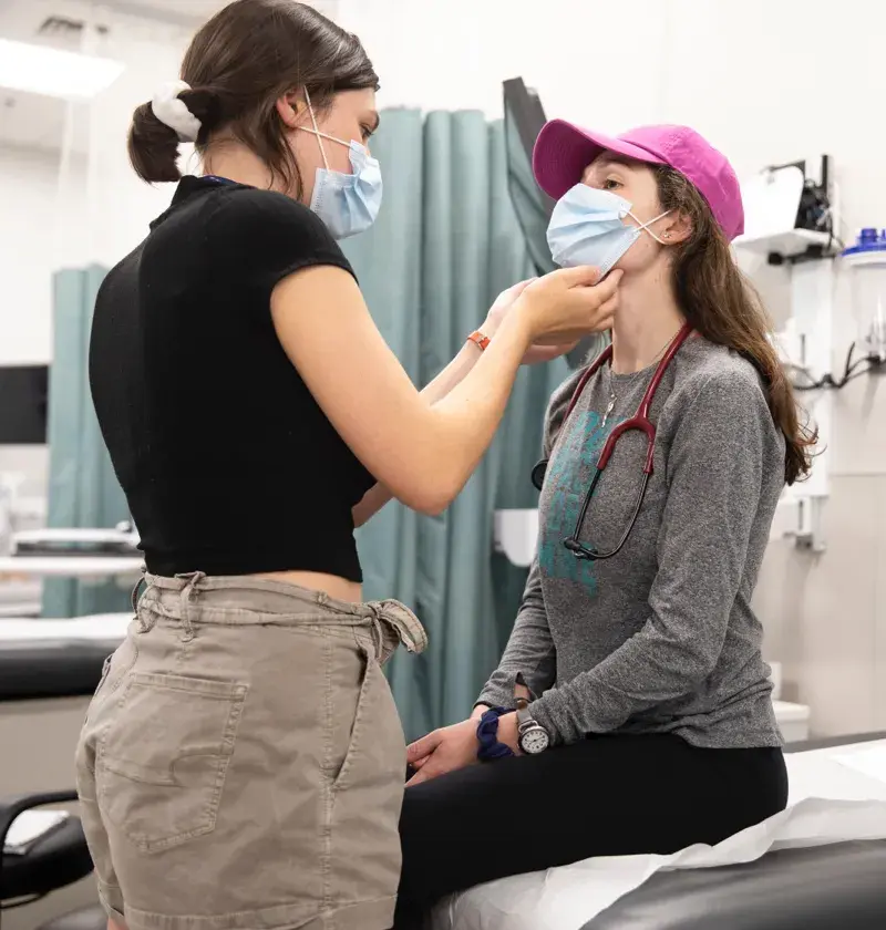 A nurse feeling under a patients chin