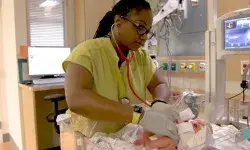 A student nurse in the MGH IHP Fast-Track BSN Program performing a newborn assessment as part of the accelerated nursing curriculum. This intensive nursing training focuses on preparing students for nursing licensure through hands-on experiences in a high-paced clinical environment.