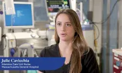 woman with long hair in scrubs talks in a hospital room